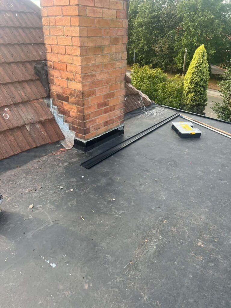 This is a photo of a flat roof which has just been repaired, there is also a chimney stack and some leadwork has also been dressed. Works carried out by Sutton in Ashfield Roofing Repairs