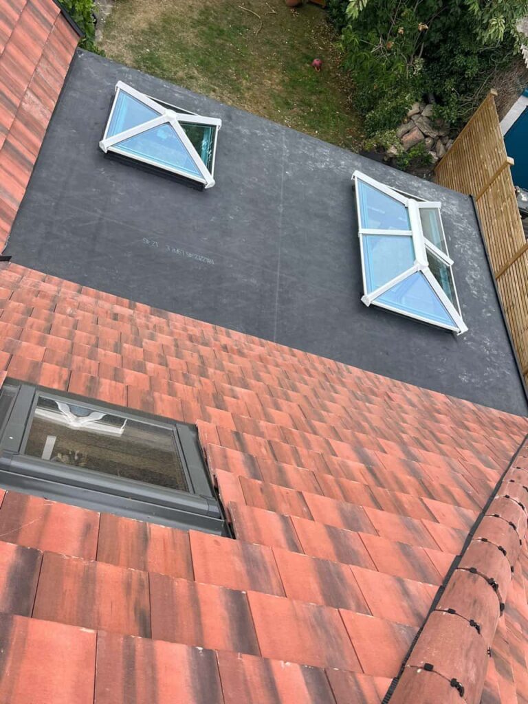 This is a photo taken from the roof ridge looking down a tiled pitched roof on to a flat roof. Works carried out by Sutton in Ashfield Roofing Repairs